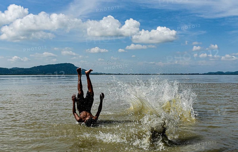 Boys jump in the Brahmaputra river during an a hot summer day in Guwahati, india on July 11, 2022