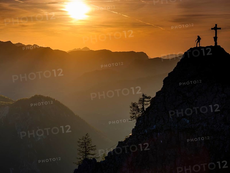 Mountaineers at the summit cross of the Kleiner Jenner at sunset, Reiteralpe in the background, Berchtesgaden National Park, Schönau am Königssee, Upper Bavaria, Bavaria, Germany, Europe