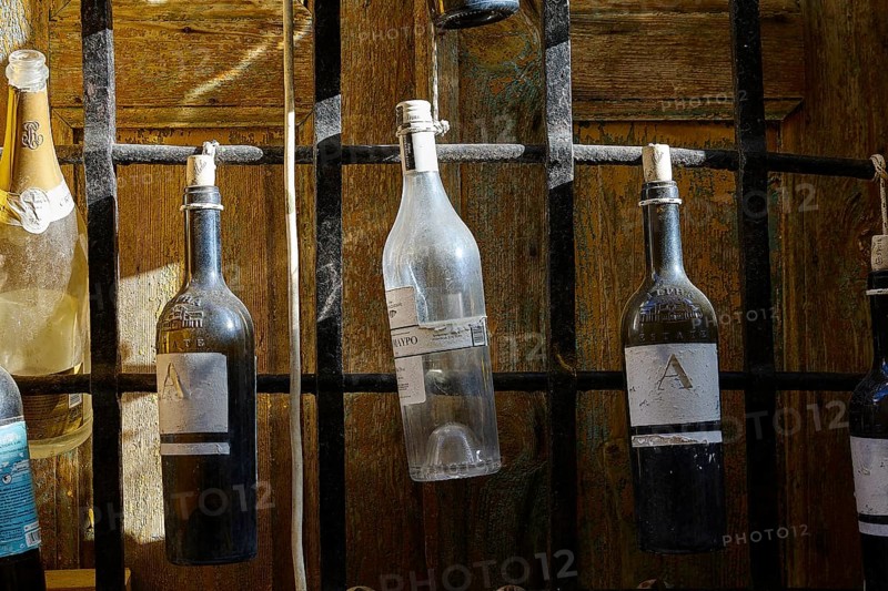 Various bottles hanging from a black metal grid, Symi Town, Symi, Dodecanese, Greek Islands, Greece, Europe