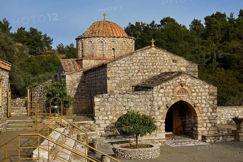 Older Byzantine church with a round tiled roof and a cross on the dome, surrounded by trees and nature, Thari Monastery, Moni Thari, near Gadouras Reservoir, lonely mountain region, Rhodes, Dodecanese, Greek Islands, Greece, Europe