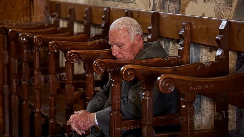 An elderly man leans back in a chair, his eyes closed as if he is sleeping, Easter 2025, Church of the Dormition of the All-Holy God Bear, Kimisis tis Theotokou, Asklipio, Rhodes, Dodecanese, Greek Islands, Greece, Europe