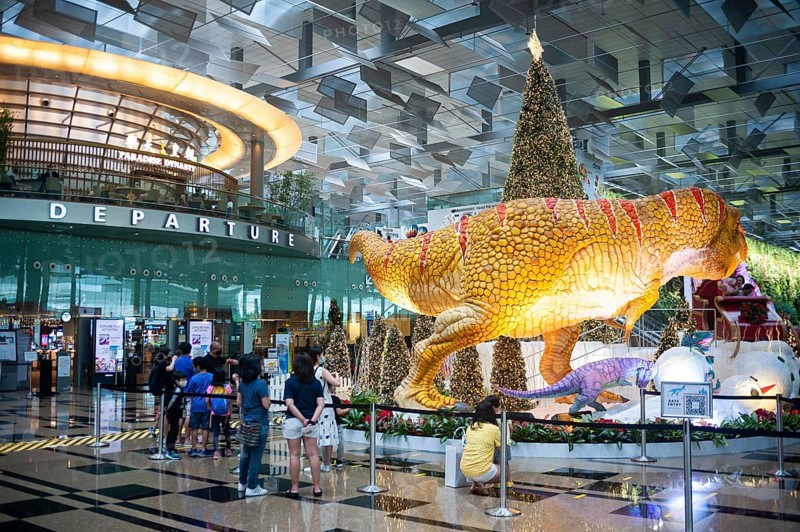 08.12.2020, Singapore, Republic of Singapore, Asia, dinosaurs, a sleigh and a Christmas tree serve as Christmas decorations and photo backdrop in Dino Wanderland for visitors and air travellers in the departure hall in Terminal 3 of Changi International Airport amid the global coronavirus (Covid-19) pandemic, Asia