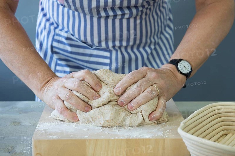 Female hands kneading bread dough