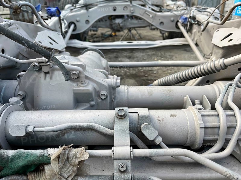 Detailed view of gearbox and mechanical parts of a vehicle in a workshop