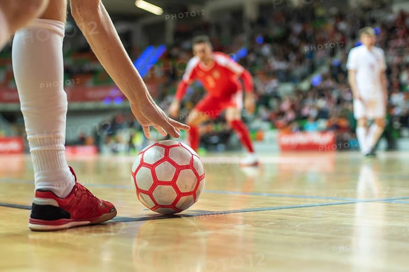 Close up of the futsal ball in the corner and player's leg