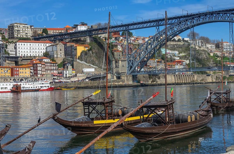 Traditional boats on Douro river with bridge in Porto, Portugal, Europe