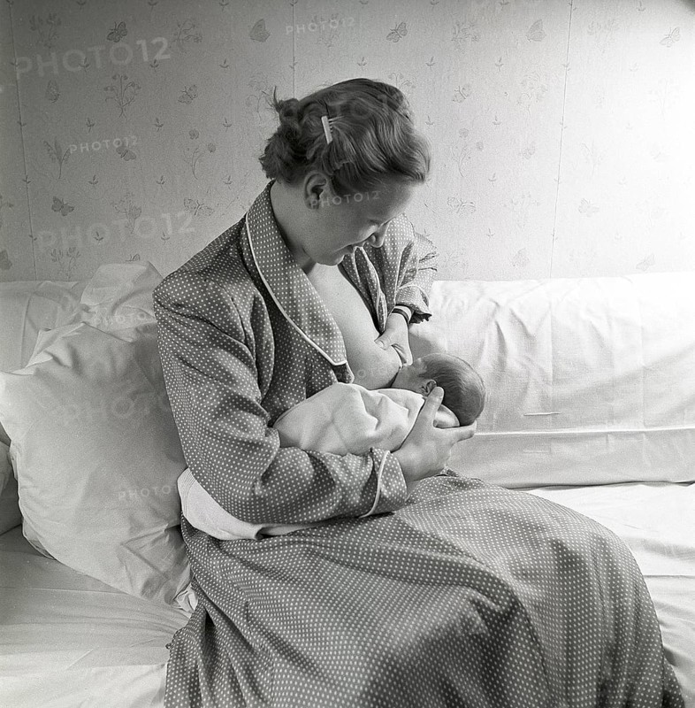 1950s mother nursing her baby. A young woman breastfeeding her baby at home. Sweden 1951 Neg CV/24