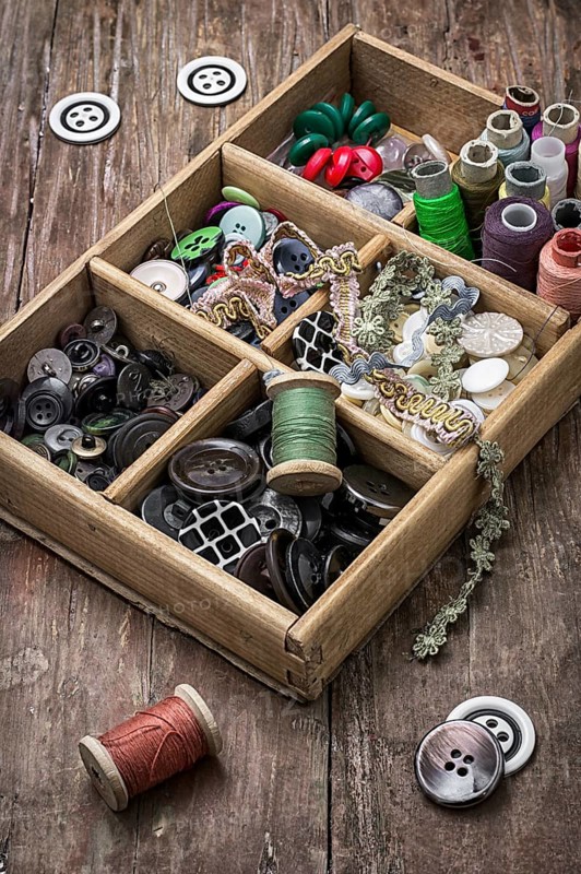 Old wooden box with thread and buttons for needlework in vintage style