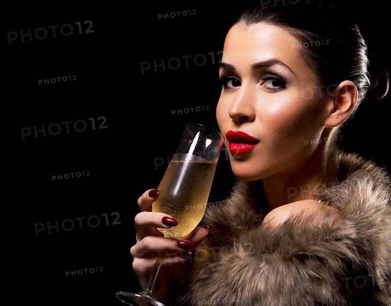 Romantic woman with golden makeup and nailpolish. Big gold fashion necklace. Black isolated background. Holding glass of champagne, Toronto, Canada, North America