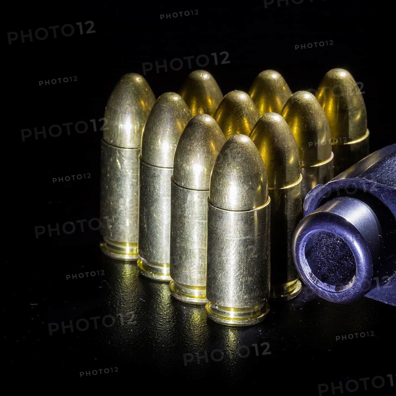 Black gun and bullets on a black background