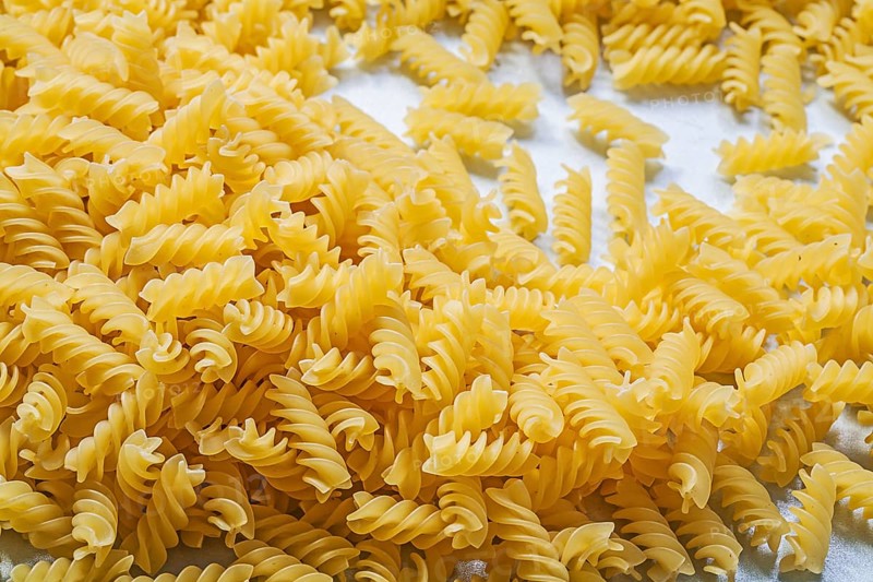 Stack of spiral macaroni on blue background food and drink concept