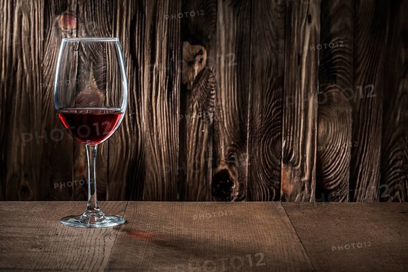 Copyspace view wineglass with red wine on vintage wooden background