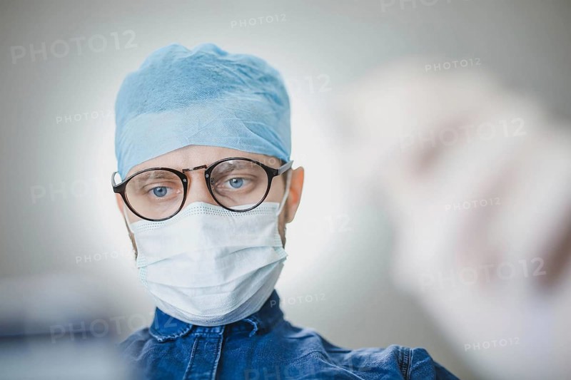 Medical professional in surgical attire concentrating in a hospital setting