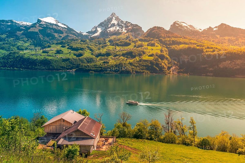 Lovely vacation destination in the Swiss Alps, around the Walensee lake. A spring scenery with mountains, lake, meadows and warm sun