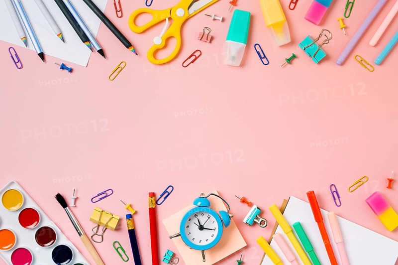 Creative student desk with school supplies and copy space in center. Top view or flat lay. Trendy back to school flat lay on pink background