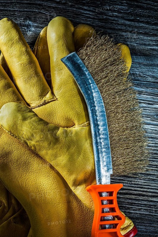 Scratch wire brush leather safety gloves on vintage wooden board