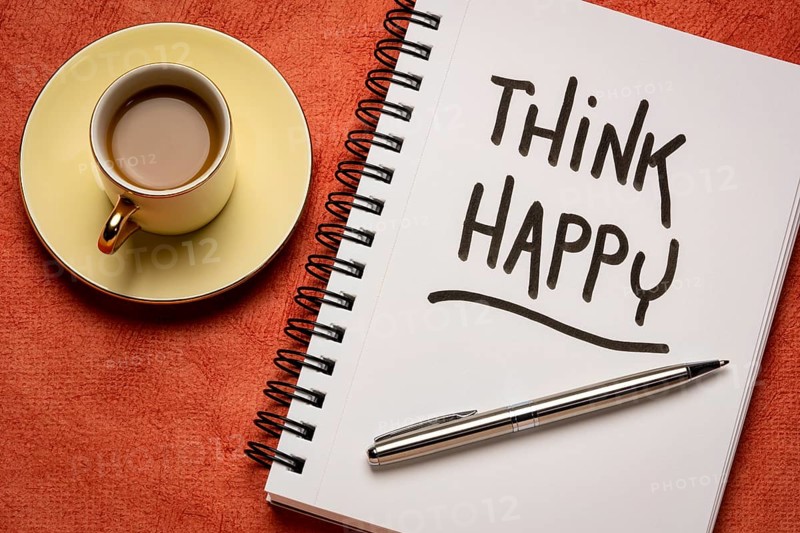 Think happy inspirational handwriting in a sketchbook with a cup of coffee, personal development, mindset, happiness and positivity concept