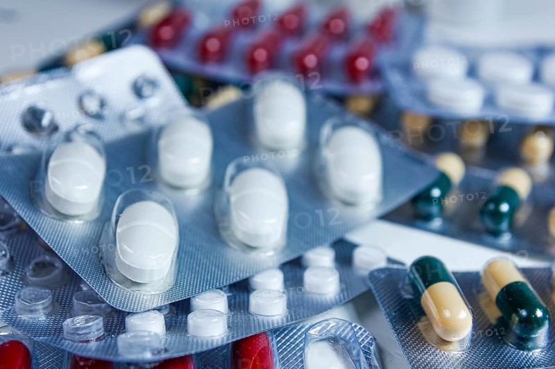 Close-up view of mixed blister packs containing white and colored capsules
