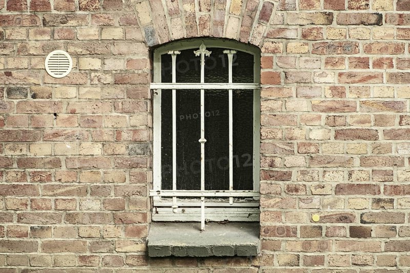 Barred cellar window in a brick wall