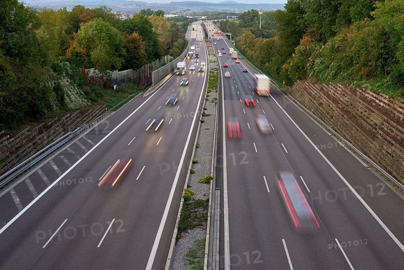Night lights from car headlights on roundabout in night city. Traces of headlights on the road at night, long exposure. Drone aerial shot. Panoramic aerial view of illuminated road overpass and road junction. traffic lights traces cars top view road top view