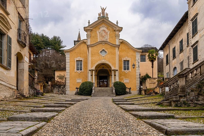 Orta San Giulio, Italy, 13 March, 2023: steep cobblestone street leading to the historic Penotti Ubertini Palace in Orta San Giulio, Europe