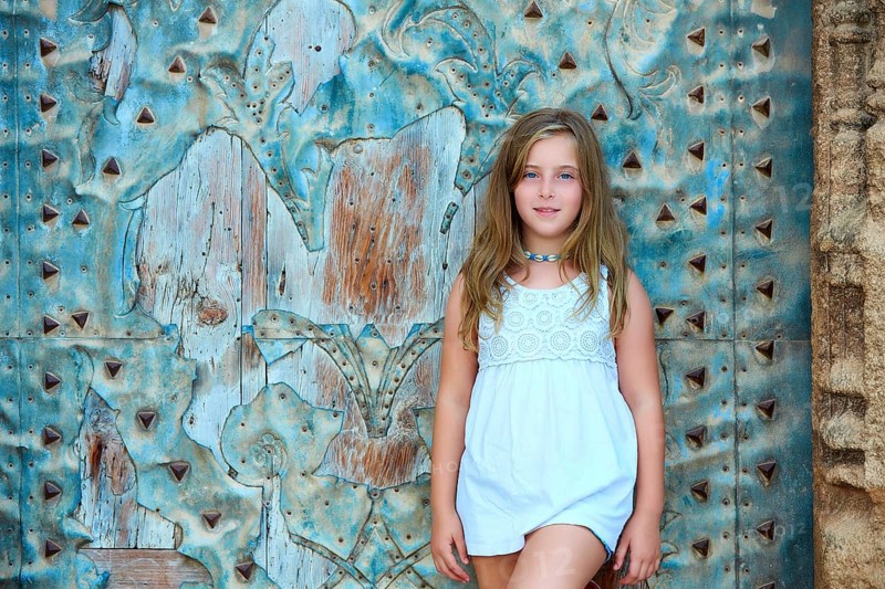 Kid girl tourist in Mediterranean old town door at Spain