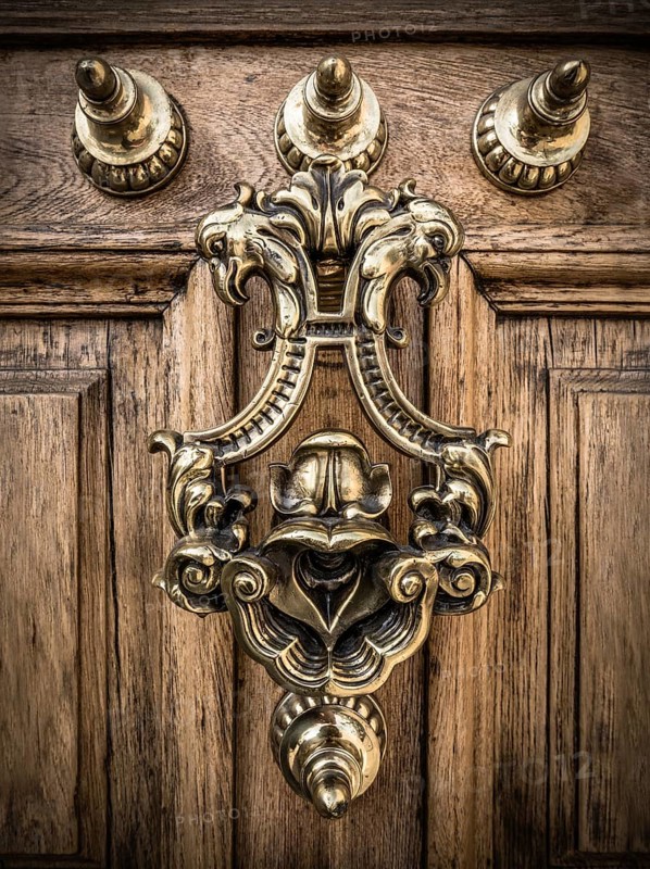 A Grand Ornate Brass Door Knocker On A Heavy Wooden Door In Spain