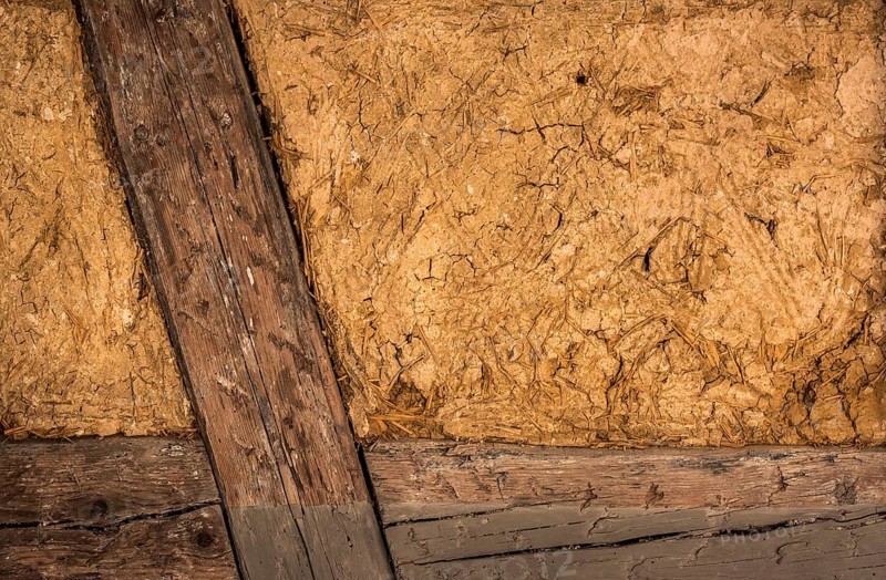 Clay house wall, with details on the wooden beams and the mixture of mud and straw, perfect as background