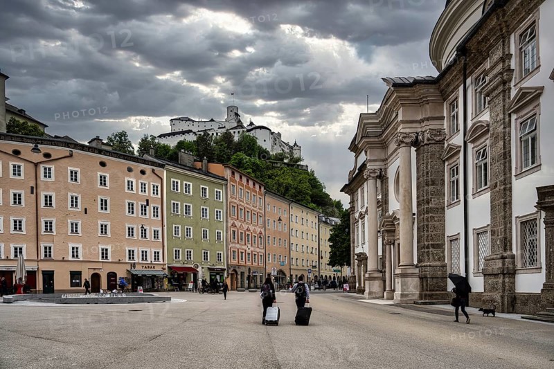 A view of the castle in Salzburg in Austria with the street scene in the foreground