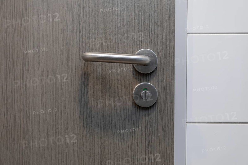 A stylish door handle rests on a beautiful wooden surface, perfectly showcasing modern design and true elegance