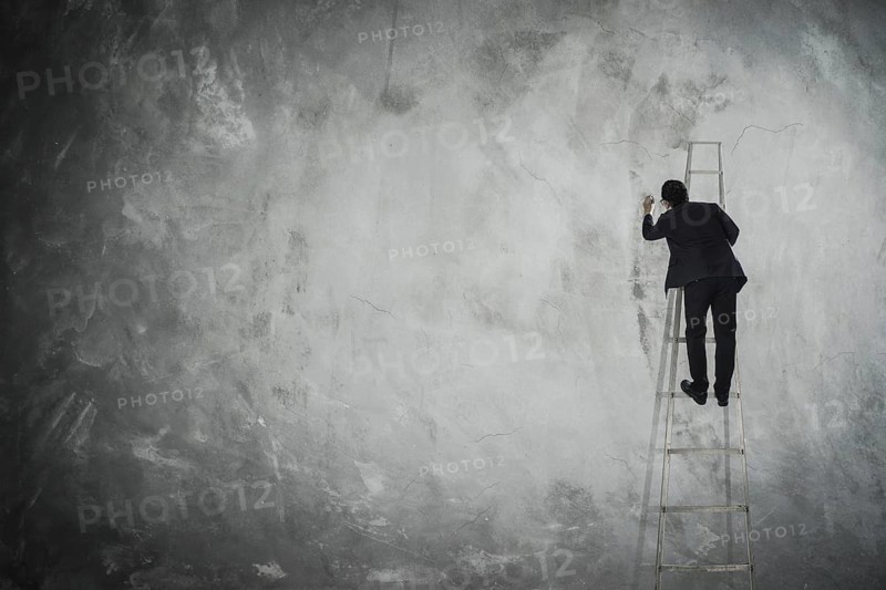 Männer zeichnen auf leere graue Wand