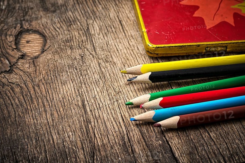 Set of colored pencils on wooden unhewn background.photo tinted