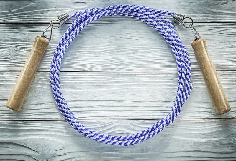 Jumping rope with wooden handles on wood board sports training concept