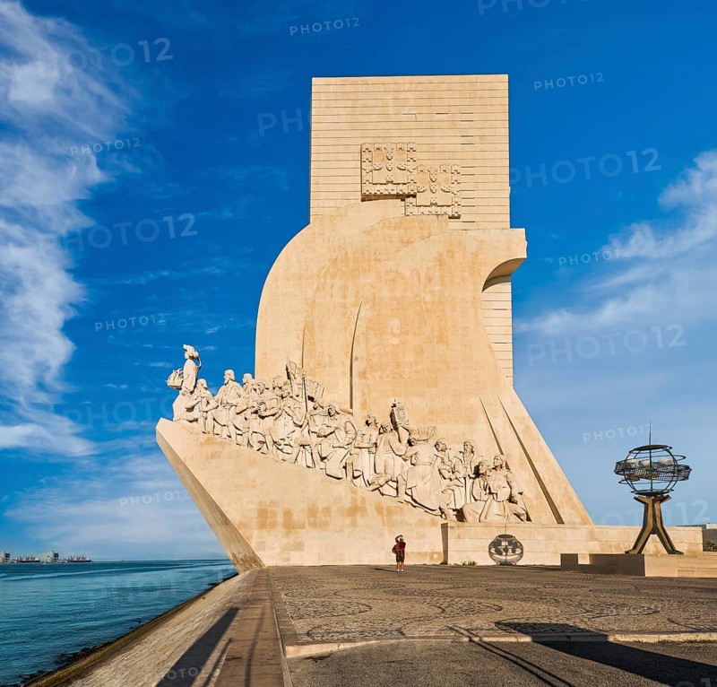 Monument to Discoveries or Padrao dos Descobrimentos to Age of Exploration, shaped as ship woth statues of Prince Henry the Navigator and great people of Portuguese seafarers history, Lisbon, Portugal, at clear blue sky on sunny day, Europe