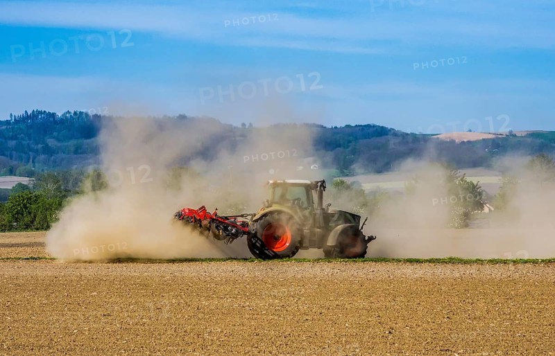 A farmer cultivates his parched field with a tractor during a dry period. Austria, Upper Austria, Eferding district