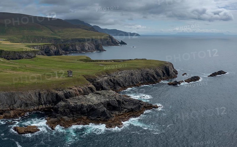 Aerial view of the rugged coastline of County Donegal at Malin Beg with the ruins of the Napoleonic signal tower on the cliff edge