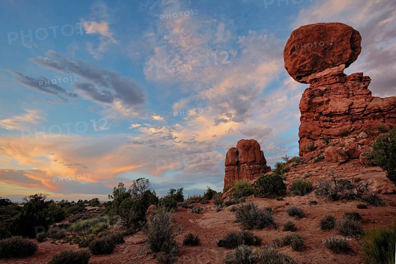 A colorful sunset glows over Balanced Rock, Arches National Park, Utah, USA, North America
