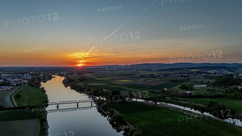 View of river and railway bridge in the light of a warm sunset, framed by fields, Danube, Bogen, Lower Bavaria