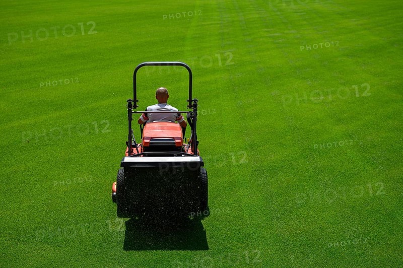 Mowing grass at the football stadium in Lubin, Poland, Europe