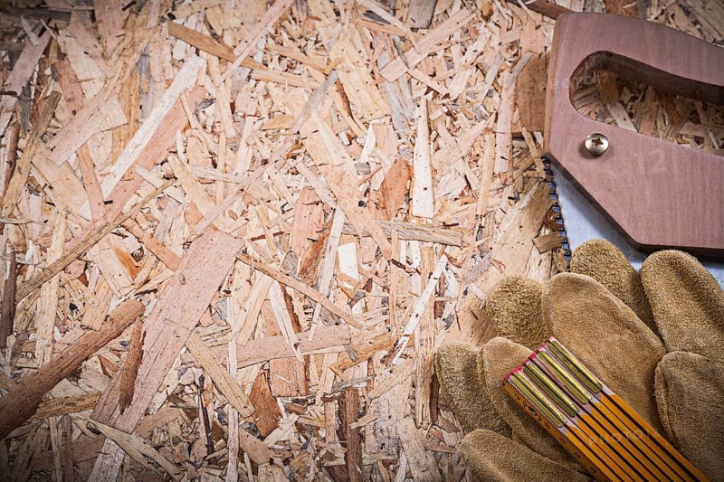 Protective leather gloves wooden meter handsaw on OSB
