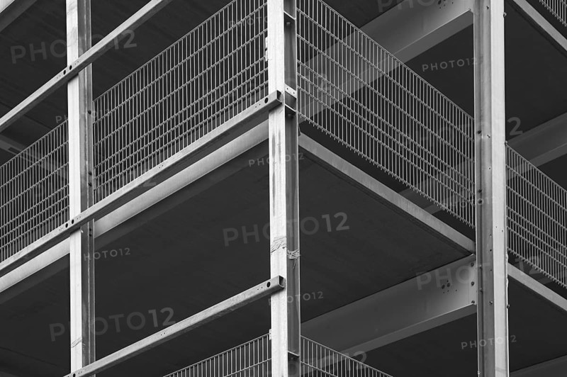 Architectural detail of a modern building highlighting steel beams and metal grids, creating a strong graphic composition