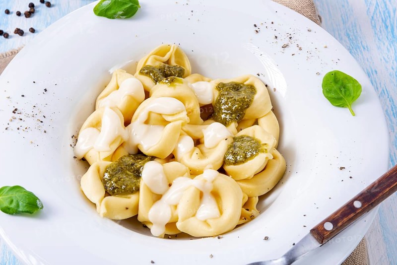 Tortellini di formaggio with basil pesto and cheese sauce