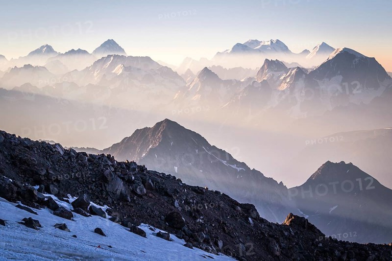 Sunrise in mountains enveloped by sun rays and mist