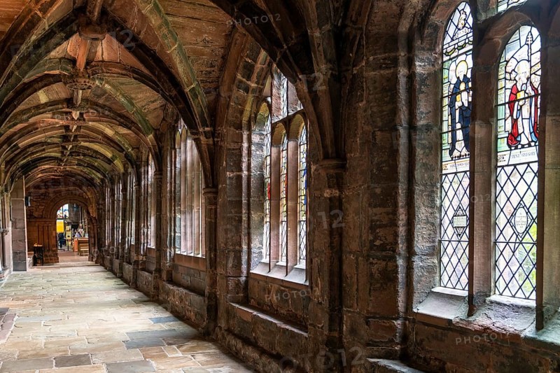 Chester, United Kingdom, 26 August, 2022: view of the cloister hallway in the courtyard of the historic Chester Cathedral with stained glass windows, Europe