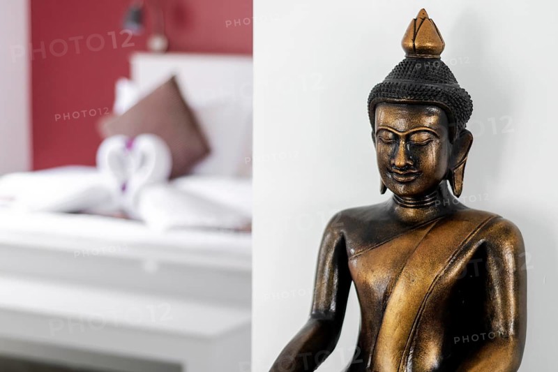 Bronze buddha statue interior design detail in modern asian home living room