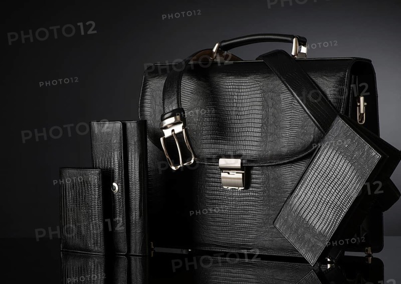 Fashionable men's set of leather accessories on a dark background. Briefcase, wallet, belt