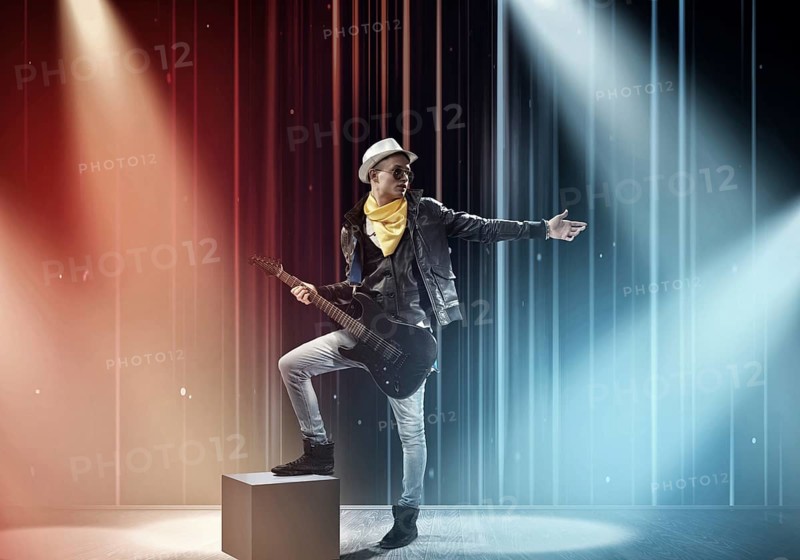 Young man rock musician in lights of stage