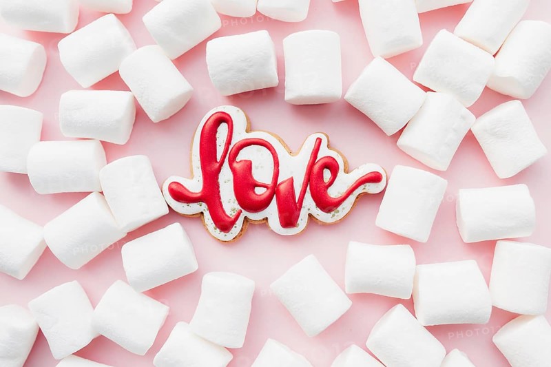 Gingerbread cookies love with white marshmallow. Valentine card. Pink background.