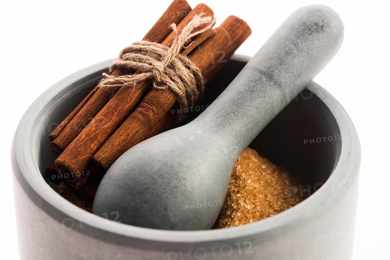 Cinnamon sticks with pure cane brown sugar in mortar