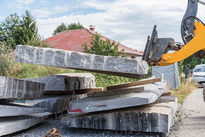 Transporting natural stone granite with a wheel loader - Front loader on construction site